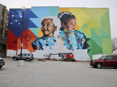 毛里西奥·拉米雷斯(Mauricio Ramirez)在密尔沃基市中心西镇社区中心的社区倡导者公司大楼上完成了大型壁画