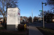 阿森松岛威斯康辛州医院密尔沃基的约瑟夫校区是一个以黑人为主的低收入社区，位于繁忙的商业街一侧和另一侧的社区之间。大楼外的指示牌上写着圣经经节。摄于12月6日。图片来源:Coburn Dukehart/Wisconsin Watch