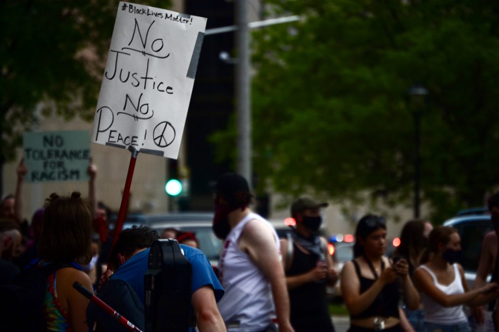 牌子上写着“没有正义，就没有和平”。图片来源:Maddy Day