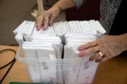 在威斯康辛州里布山市中心，首席选举监察员沙伦·德雷夫辛斯基(Sharon Drefcinski)将通过邮件收到的缺席选票按字母顺序排列和整理。在2020年8月11日的党派初选中。镇办事员Joanne Ruechel在选举前发出了1348张缺席选票。科伯恩·杜克哈特/威斯康星新闻调查中心