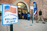 2022年11月8日星期二上午，选民在威斯康星州斯托顿的斯托顿消防部门参加中期选举投票之前进入一个投票站。安琪拉主要/ WPR