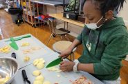 一名参加FoodRight青年厨师学院项目的学生根据学校制作的健康食谱切苹果。图片由FoodRight提供。